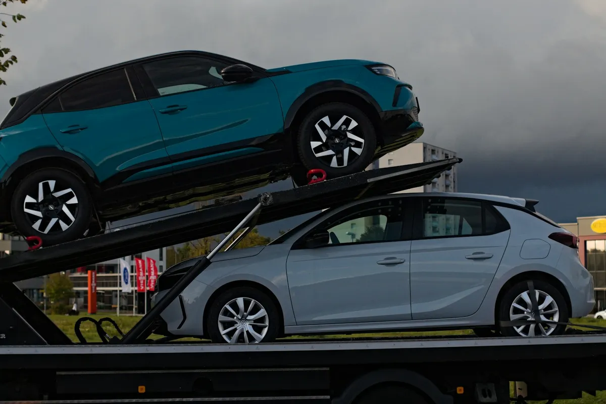 Two cars secured on an open transport carrier