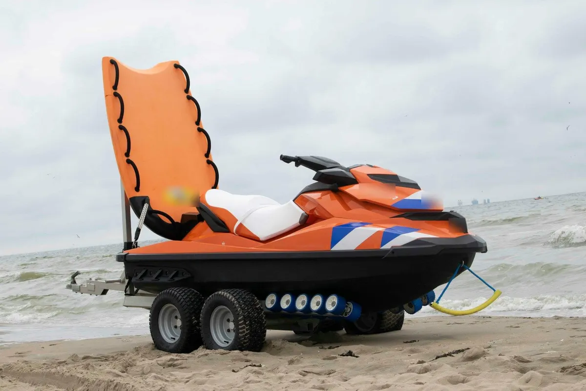 Jet ski transport: personal watercraft strapped to a twin-axle trailer on a beach