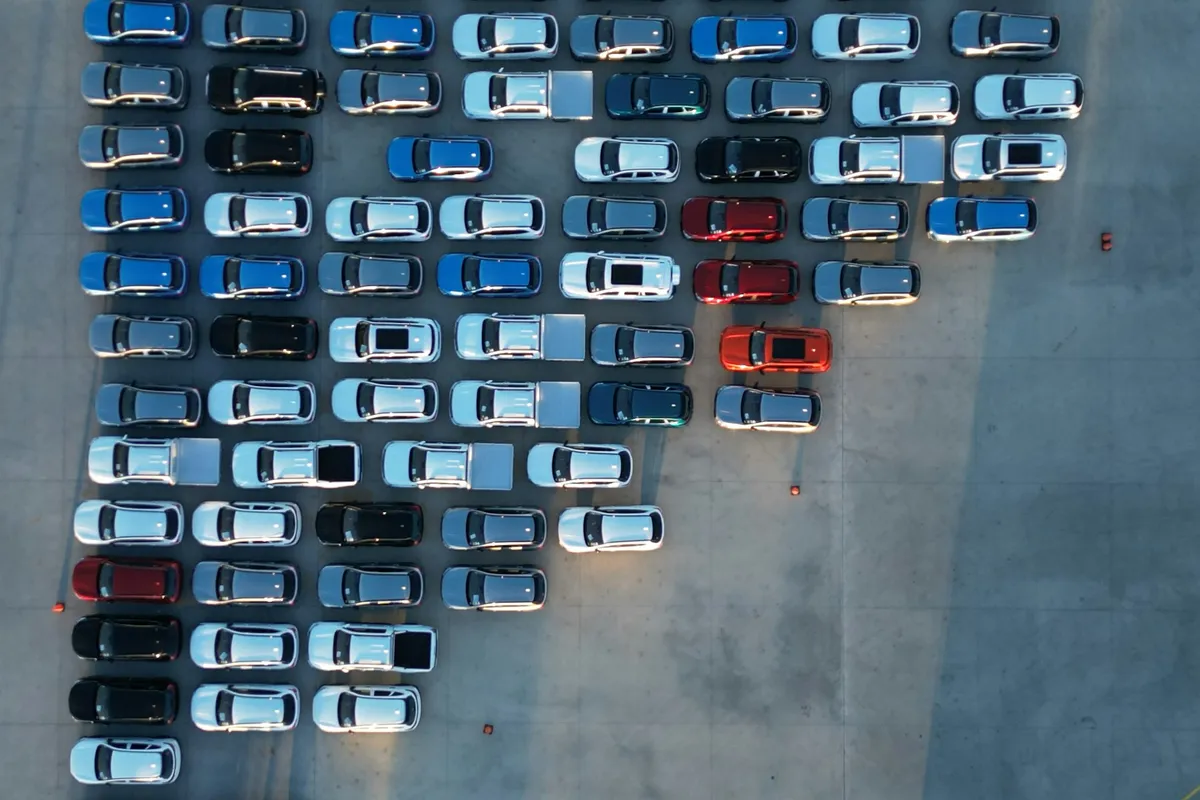 Terminal-to-terminal car shipping: aerial view of rows of vehicles parked in a storage yard